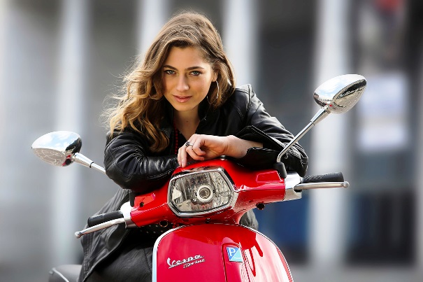 Mujer en su moto luciendo chaqueta. | Piaggio Press Group