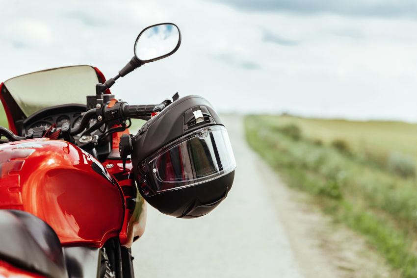 moto deportiva parada en un camino con un casco integral colgado del manillar
