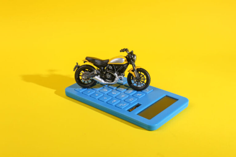 miniatura de una moto encima de una calculadora azul